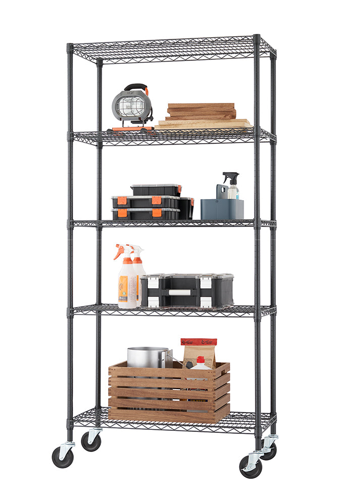A tall, five-tier black wire shelving unit with casters holds various items, suggesting use in a garage or utility space. Contents include wood planks, toolboxes, spray bottles, and a large wooden crate with metal and paper items.