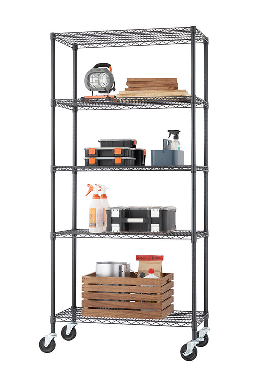 A tall, five-tier black wire shelving unit with casters holds various items, suggesting use in a garage or utility space. Contents include wood planks, toolboxes, spray bottles, and a large wooden crate with metal and paper items.