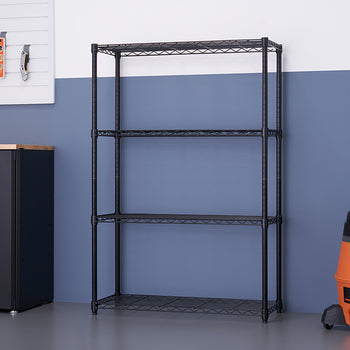 A close-up, eye-level shot shows a black metal, four-tier wire shelving unit. The unit is standing on a light gray concrete floor in what appears to be a clean garage with two-tone blue and white walls.