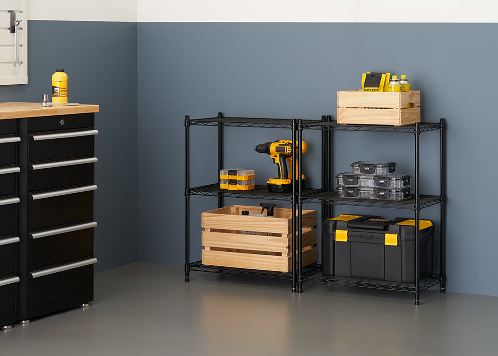 A four-shelf black wire shelving unit is shown against a gray wall, holding various tools and storage containers. On the shelves are two natural wood crates, a yellow and black cordless drill, several clear and yellow parts organizers, and a large black and yellow toolbox.