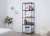 A five-tier black wire shelving unit stands against a white wall, organized with various items including books, storage bins, and a small red dog figurine. The minimalist room also features a potted plant, two hexagonal wall shelves, and the edge of a bed with striped bedding.