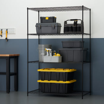 A black wire shelving unit stands against a two-toned wall (white above, dark blue below), organized with various gray and black storage containers and toolboxes. The shelves hold items like tool chests, a caddy with spray bottles, and two large black and yellow-lidded storage bins.