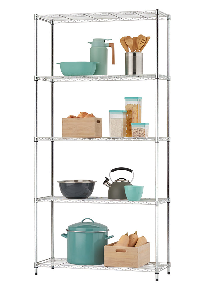 A chrome-plated wire shelving unit stands against a white background, neatly organized with various kitchen essentials on its five tiers. Shelves display items including teal mixing bowls and a carafe, wooden cooking utensils, stacked dried pasta and rice containers, a wooden bin of onions, a charcoal mixing bowl, a grey stovetop kettle, a large teal stockpot, and a wooden bin of butternut squash.
