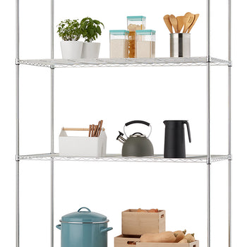 A four-shelf chrome wire rack holds a variety of kitchen items including potted herbs, dry goods in canisters, utensils, a tea kettle, and a large blue stockpot. The bottom shelves feature wooden storage crates filled with produce like onions and squash, all organized against a white background.