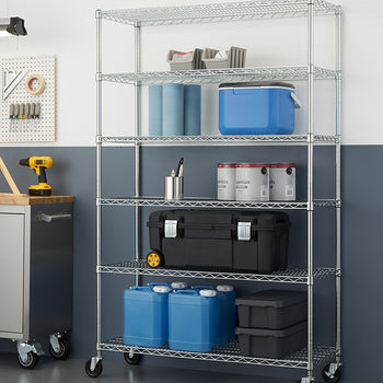 A six-tier chrome wire shelving unit on caster wheels, positioned against a half-painted blue and white wall in a garage or workshop environment. The shelves are stocked with various utility items, including large blue plastic jugs, a wheeled black toolbox, paint cans, a blue cooler, and workshop paper towels.