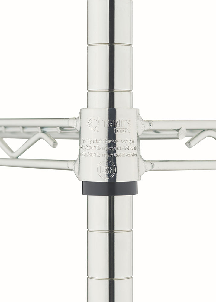 A close-up shot of the corner collar joint of a chrome wire shelf, showing where it connects to a vertical supporting post over a black plastic slip sleeve. The metal collar is stamped with the "TRINITY PRO" logo, an NSF certification mark, and text detailing weight capacities for evenly distributed loads.