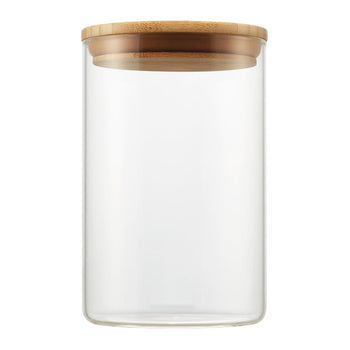 A clear, medium cylindrical glass canister is shown with a round, light brown bamboo lid resting on top. The canister is empty and isolated against a white background.