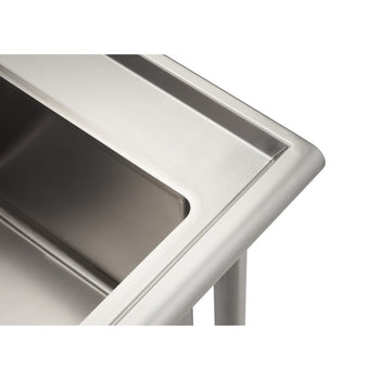 A close-up shot shows the corner of a stainless steel utility sink. The smooth, metallic surface reflects light, highlighting the curved edge and the interior basin.