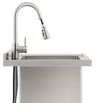 A profile view of a modern, brushed stainless steel kitchen faucet with a high-arc spout and pull-down sprayer mounted on a matching utility sink. The faucet's flexible supply lines are visible extending below the countertop against the sink's rectangular basin.