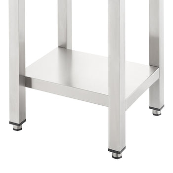 A close-up shot shows the bottom section of a stainless steel utility table featuring four square legs and a lower storage shelf. The legs are equipped with black adjustable leveling feet for stability on uneven surfaces.