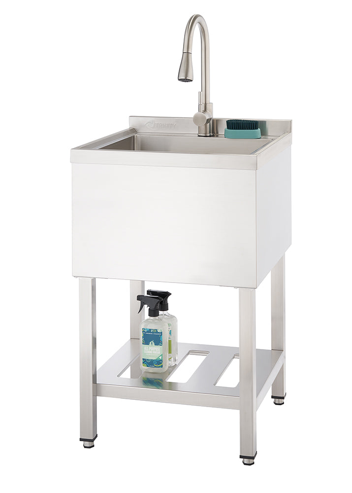 A stainless steel utility sink with a faucet is shown against a white background. The sink stands on four legs with an open shelf below, holding two spray bottles.