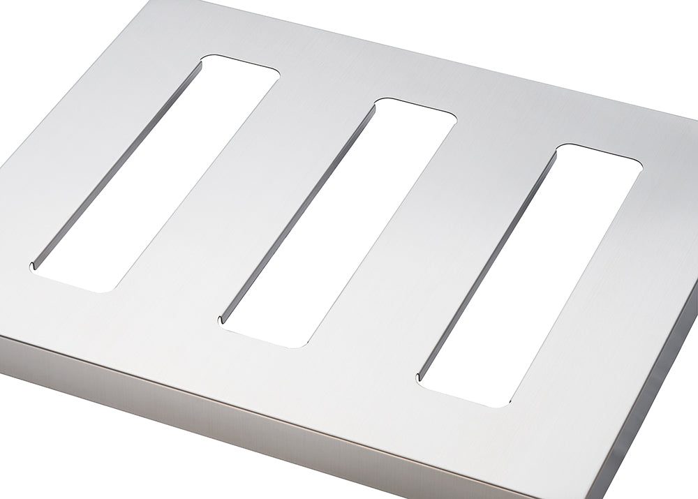A close-up shot shows a rectangular, brushed metal plate with three elongated, rectangular cutouts running parallel to each other. The cutouts allow visibility of the white background behind the plate.