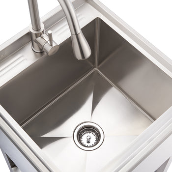 A high-angle shot shows a sleek, square-shaped stainless steel utility sink with a modern gooseneck faucet. The sink has a visible drain at its center, and the surface appears polished and reflective.