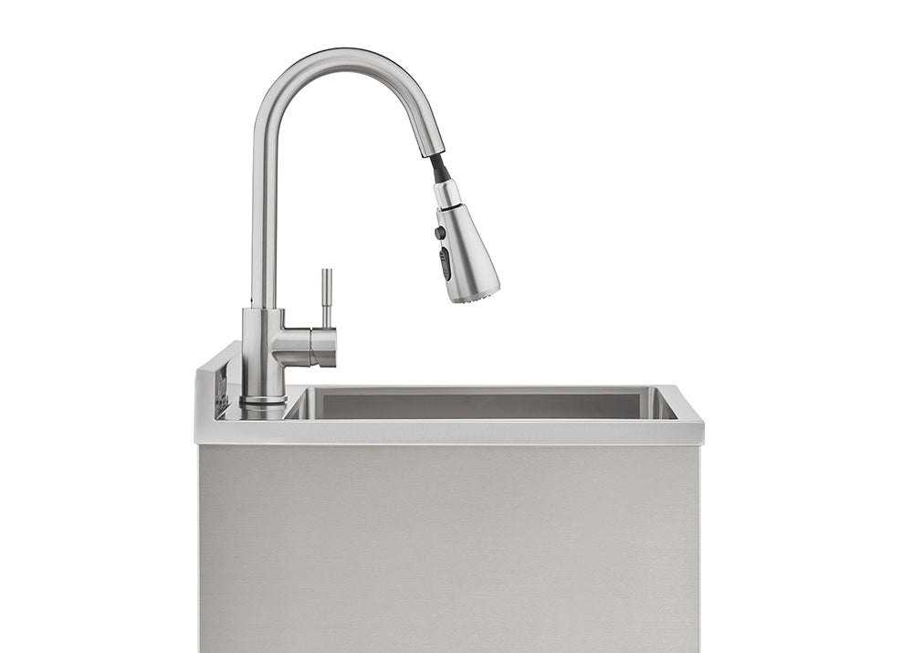 A sleek, brushed stainless steel gooseneck faucet with a pull-down sprayer is mounted on a matching industrial-style utility sink. The modern faucet features a single-lever handle and is set against a clean, white background.