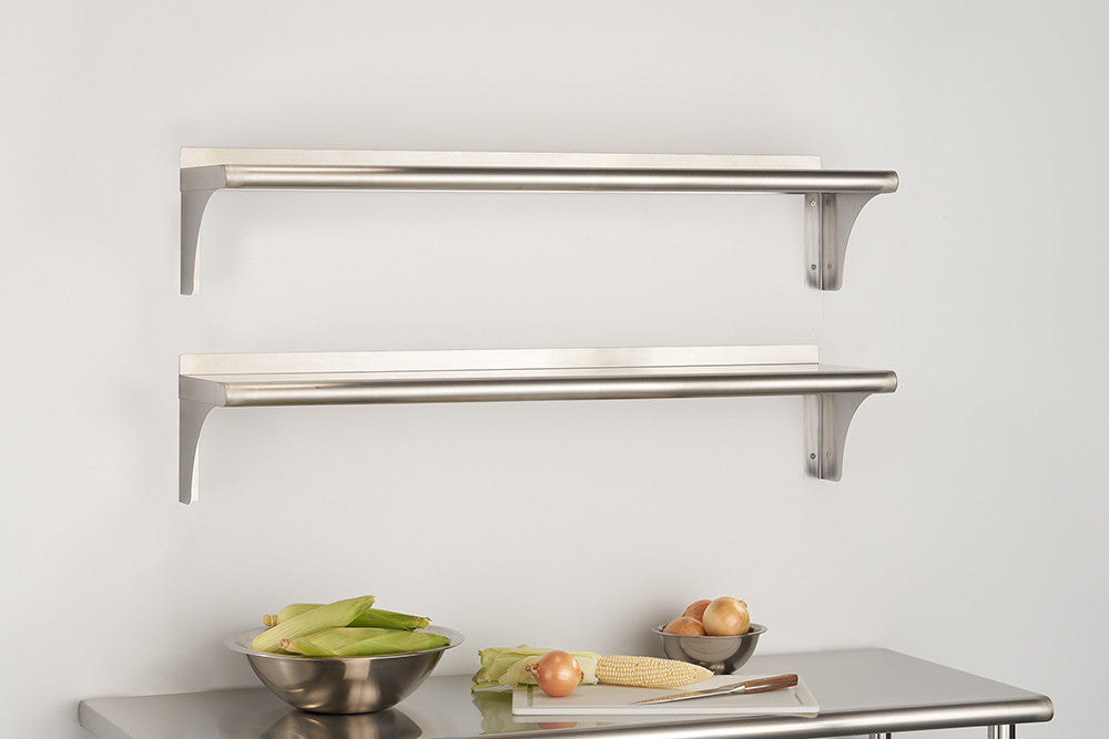 Two stainless steel rectangular bracket shelves are mounted on a white wall above a stainless steel countertop. Bowls of vegetables and a cutting board with an onion and corn are on the counter below.