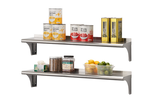 Two stainless steel shelves are mounted on a white wall, holding various food items. The top shelf contains four cans of corn, two cans of whole peeled tomatoes, and two gold-colored boxes, while the bottom shelf holds jars of dry goods, a box, and clear plastic containers of citrus fruits.
