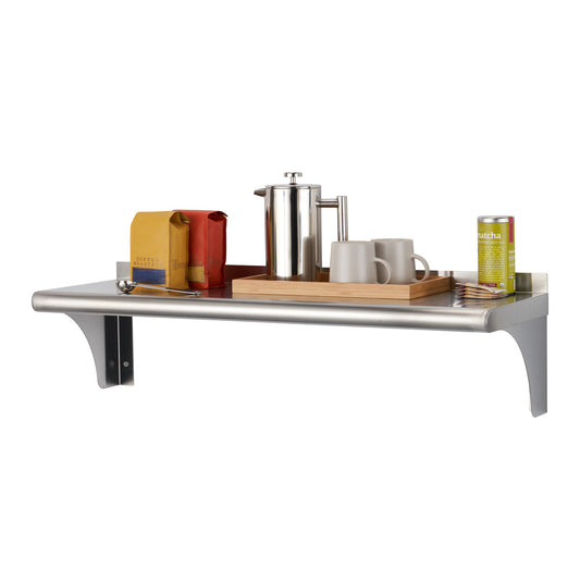 A stainless steel wall shelf is shown against a white background, holding a tray with a French press, two mugs, coffee beans, and a matcha container. The shelf has a curved front edge and two triangular supports.