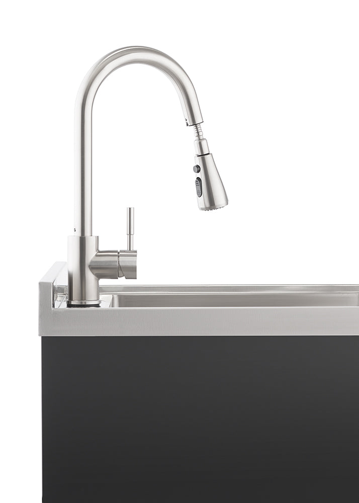 A modern, brushed stainless steel kitchen faucet with a pull-down spray head is mounted on a sleek, dark grey countertop with an integrated sink. The faucet's high-arc design and minimalist lever handle suggest contemporary style and functionality.