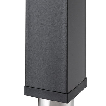 A close-up shot shows the bottom of a matte black, rectangular table leg. It features a brushed metal foot that tapers slightly and is capped with a black, slightly angled base.