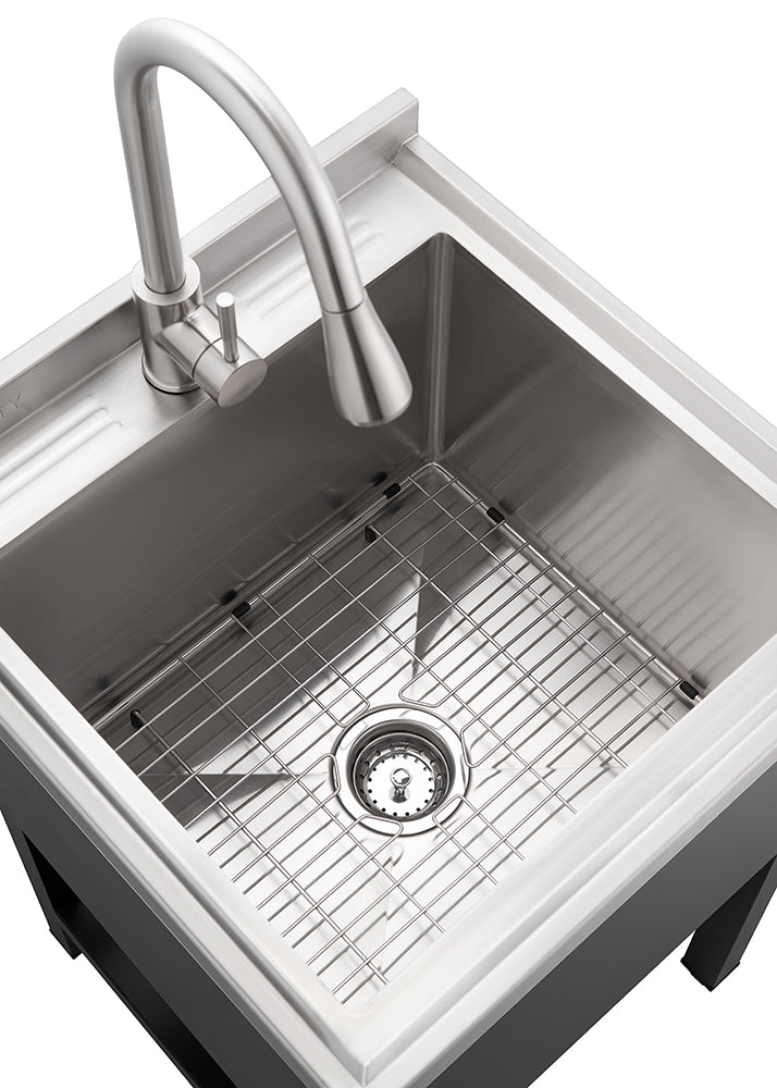 A top-down view shows a stainless steel utility sink with a brushed metal gooseneck faucet. A metal grid rack sits at the bottom of the basin, and the sink is set into a dark-colored cabinet base.