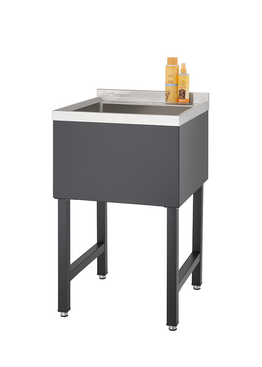 A tall, rectangular black utility sink with a stainless steel basin stands on four black legs. Two bottles of orange-labeled cleaning products are placed on the back edge of the sink.