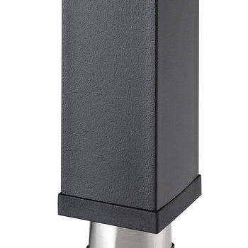 A close-up shot shows the bottom of a black, square table leg with a subtle textured finish. It rests on a short, brushed metal foot that is slightly wider than the leg, with a black, tapered base.