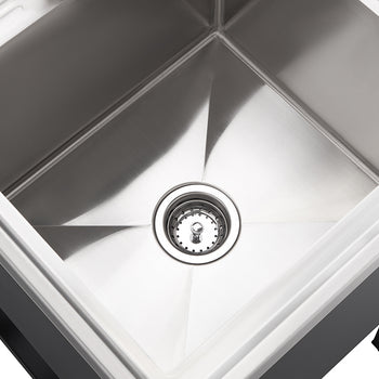 A top-down view shows a clean, square, stainless steel sink with a drain in the center. The sink appears to be mounted within a dark countertop or cabinet, visible along the bottom and sides of the image.