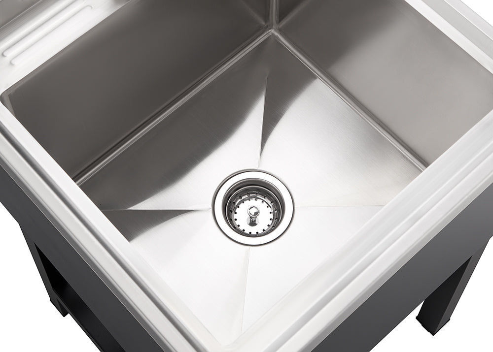 A top-down view shows a clean, square, stainless steel sink with a drain in the center. The sink appears to be mounted within a dark countertop or cabinet, visible along the bottom and sides of the image.
