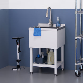 A well-organized utility room features a white utility sink with a brushed nickel faucet and a blue hand towel hanging from the basin. To the left is a bicycle pump, and to the right, a metal shelving unit holds various storage containers and a blue cooler.