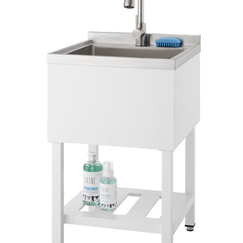 A modern, white utility sink with a stainless steel basin and a gooseneck faucet stands on white legs. A lower slatted shelf holds two bottles of cleaning solution, and a blue scrub brush rests on the edge of the sink.