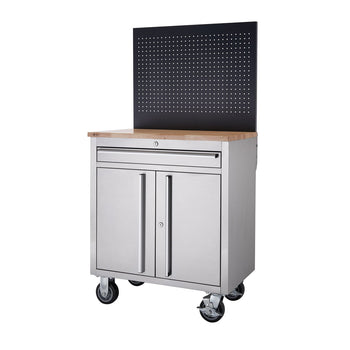 A stainless steel rolling workbench with a light-colored wooden top, cabinet doors, a drawer, and a black pegboard backing is shown against a white background. The workbench has four wheels, two of which appear to have locks.