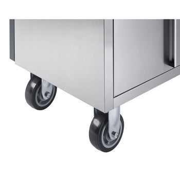 Close-up view of the bottom corner of a stainless steel workbench, showing two black caster wheels with gray centers. The polished metal surface of the workbench reflects some light.