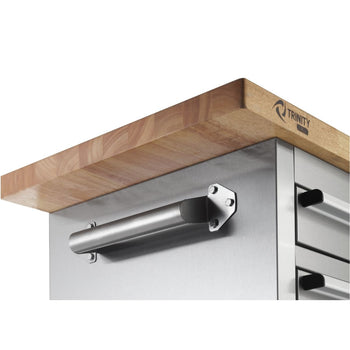 A close-up shows the corner of a stainless steel rolling workbench with a thick, light-colored wooden butcher block countertop. A horizontal stainless steel handle is attached to the side of the workbench with hexagonal bolts.