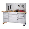 A stainless steel rolling workbench with a light wood countertop and a pegboard backing is shown against a white background. The workbench features multiple drawers and a cabinet, and various tools are organized on the pegboard and countertop.