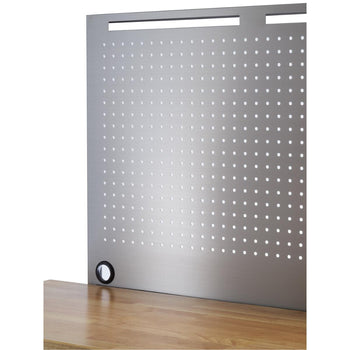 A close-up shows a section of a stainless steel pegboard attached to a light brown wooden workbench. The pegboard has evenly spaced rows and columns of small, circular holes and a few horizontal slots at the top.