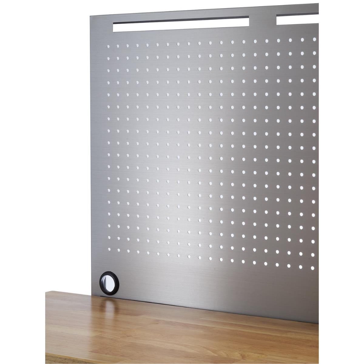A close-up shows a section of a stainless steel pegboard attached to a light brown wooden workbench. The pegboard has evenly spaced rows and columns of small, circular holes and a few horizontal slots at the top.