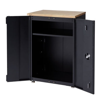 A black freestanding steel garage cabinet with a light-colored wooden top has both of its doors open, revealing an interior shelf. The cabinet has silver circular feet and visible hinges and latching mechanisms on the doors.