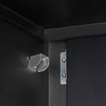 A close-up shot shows the interior of a black metal cabinet. Visible are a silver magnetic door catch on the left side panel and a silver hinge attached to the right side of the cabinet opening.