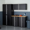 A black, six-piece garage cabinet set, likely the Trinity brand, arranged against a two-toned wall in a garage setting. The set includes tall standing cabinets, base cabinets with a light-colored wooden countertop, and wall-mounted cabinets, offering ample storage space.