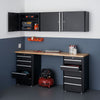 This is a well-organized garage space featuring a Trinity 6-piece garage cabinet drawer set in black with a wooden countertop. The set includes wall-mounted cabinets above a workbench with base cabinets and drawers on either side, providing ample storage and a functional workspace.