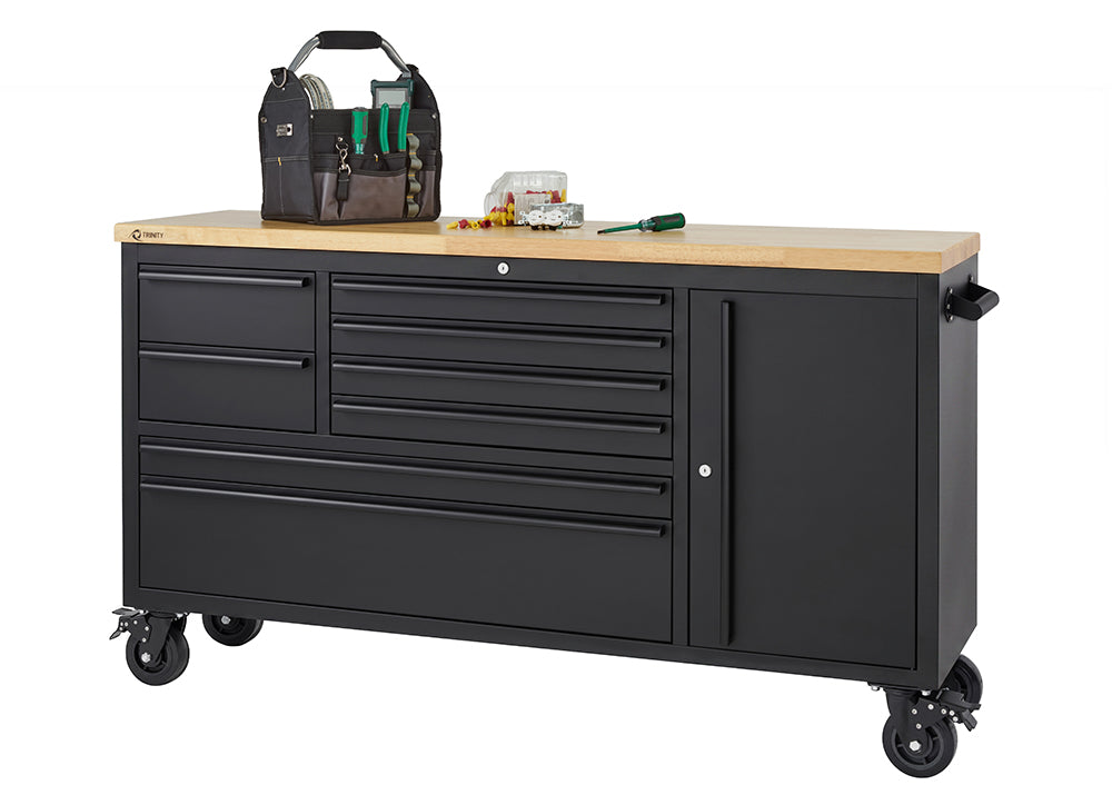 A matte black mobile tool workbench with a light wood top sits on heavy-duty locking casters against a plain white background. The unit features multiple closed drawers and a tall side cabinet, with a tool bag, screwdriver, and small hardware placed on top.