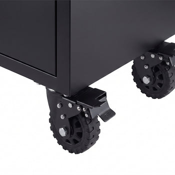 A close-up view shows two heavy-duty black caster wheels mounted to the bottom corner of a matte black tool cabinet. Each swiveling wheel is equipped with a metal locking lever to secure the mobile unit in place.