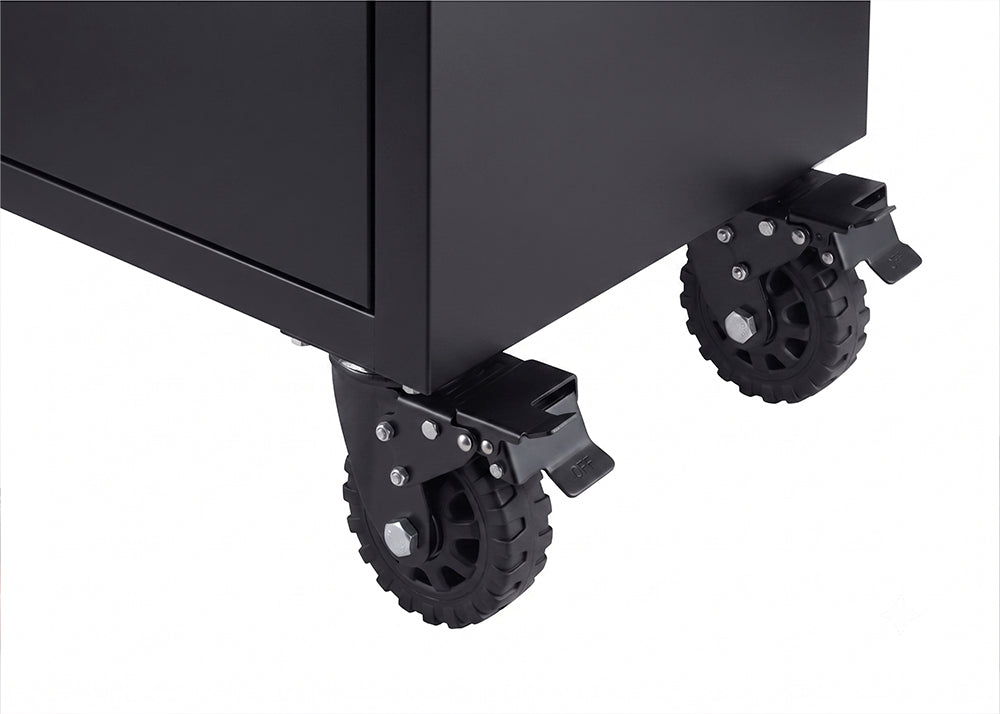 A close-up view shows two heavy-duty black caster wheels mounted to the bottom corner of a matte black tool cabinet. Each swiveling wheel is equipped with a metal locking lever to secure the mobile unit in place.