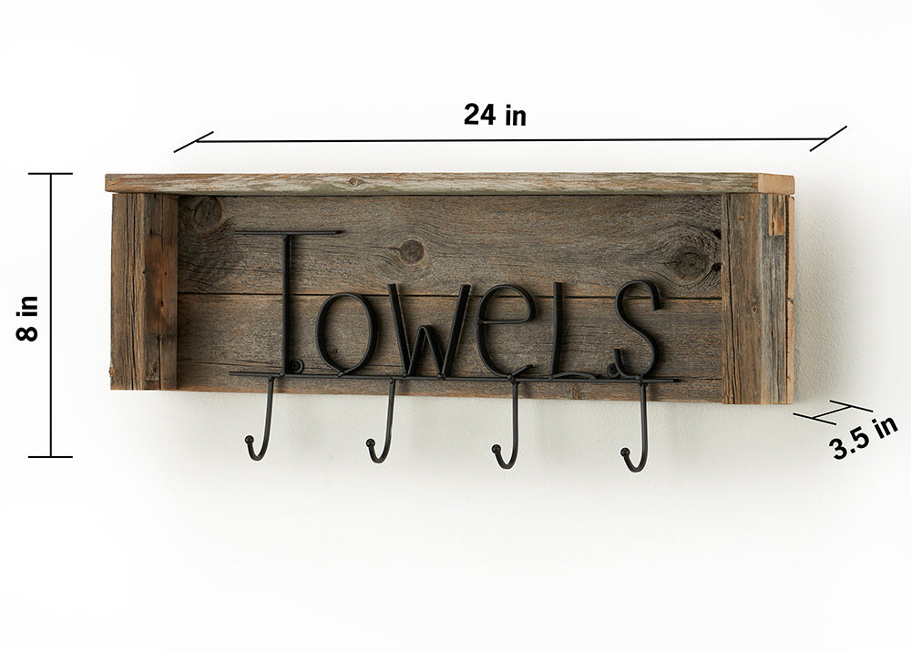 A rustic wooden shelf, 24 inches wide, 8 inches high, and 3.5 inches deep, is mounted against a white wall. The shelf has "TOWELS" spelled out in black metal letters with four hooks underneath, designed for hanging towels.