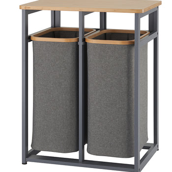 A laundry sorter featuring two tall, rectangular gray fabric hampers with a wooden rim. The hampers are held within a dark gray metal frame, which has a light wood countertop on top.