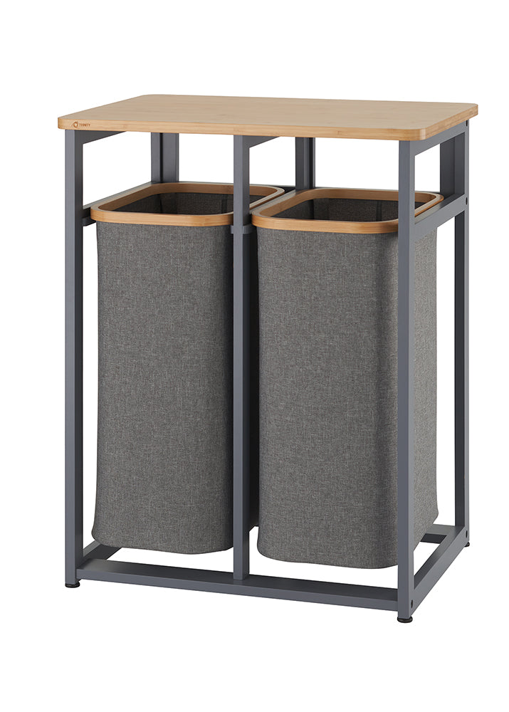 A laundry sorter featuring two tall, rectangular gray fabric hampers with a wooden rim. The hampers are held within a dark gray metal frame, which has a light wood countertop on top.