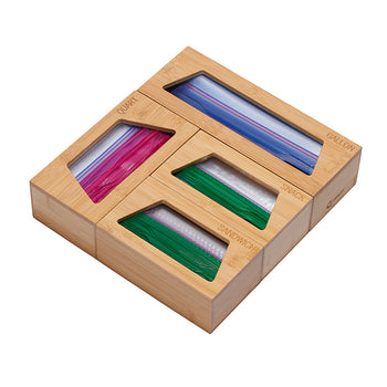 A light wood bamboo organizer for plastic bags is shown from an eye-level, slightly angled perspective against a white background. The organizer has four compartments labeled 