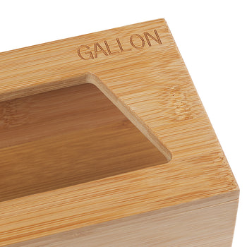 A close-up shot shows a light-colored wooden box with a rectangular cutout on top. The word 