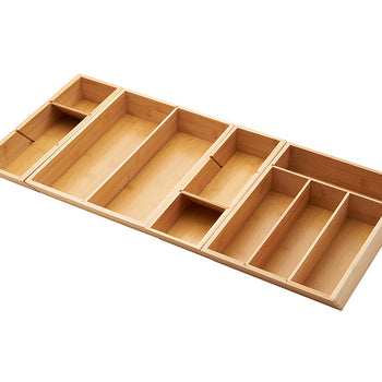 A bamboo drawer organizer is shown at a slight angle on a white background. The organizer is expandable and has multiple compartments of various sizes to hold utensils and kitchen gadgets.