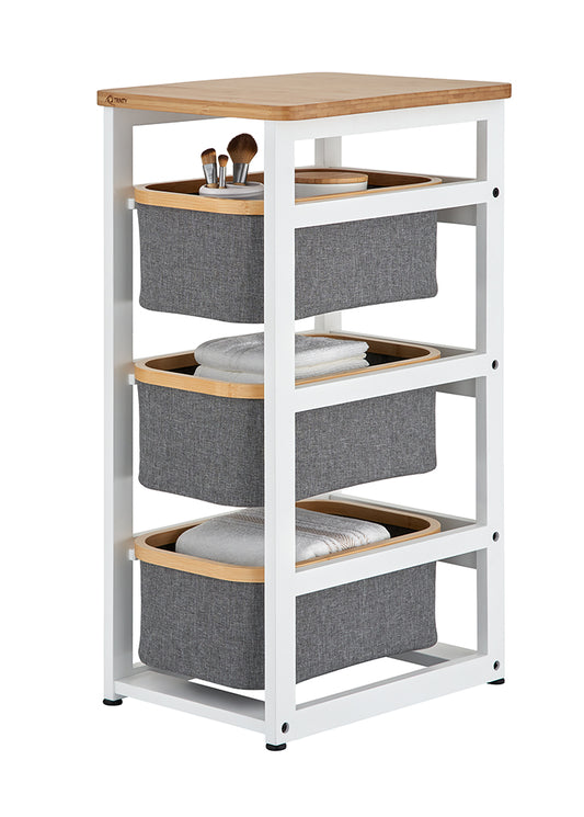 A white-framed storage cart features a light-wood top and three tiers of gray fabric bins with matching wood trim. The bins are shown holding bathroom essentials like makeup brushes and folded white towels.